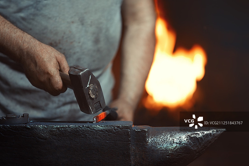 铁匠在锻造车间工作的手部特写图片素材