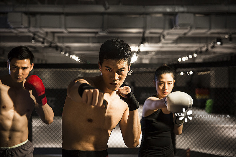三个青年男女在健身房练习拳击图片素材