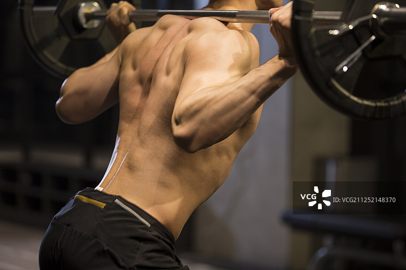青年男子在健身房举重特写图片素材