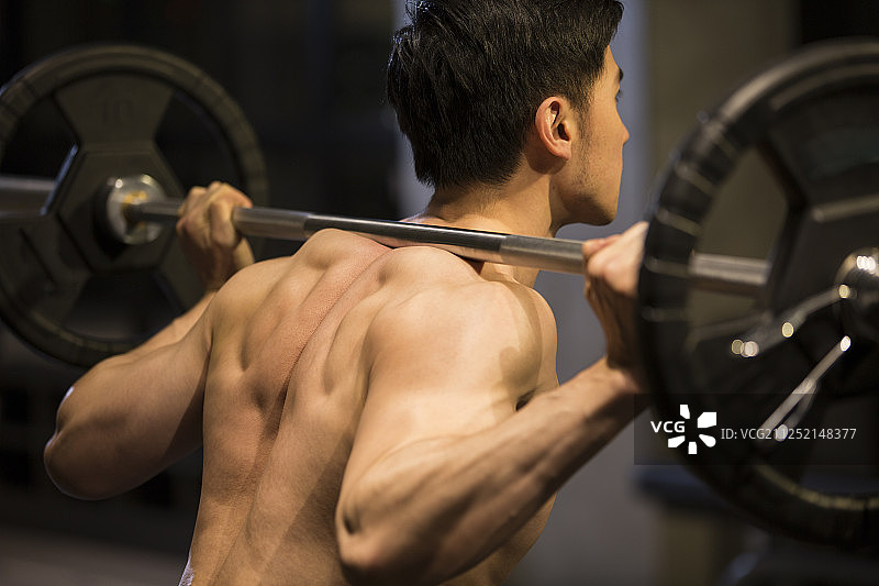 青年男子在健身房举重特写图片素材