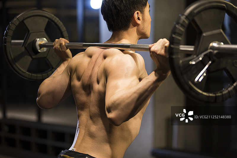 青年男子在健身房举重特写图片素材
