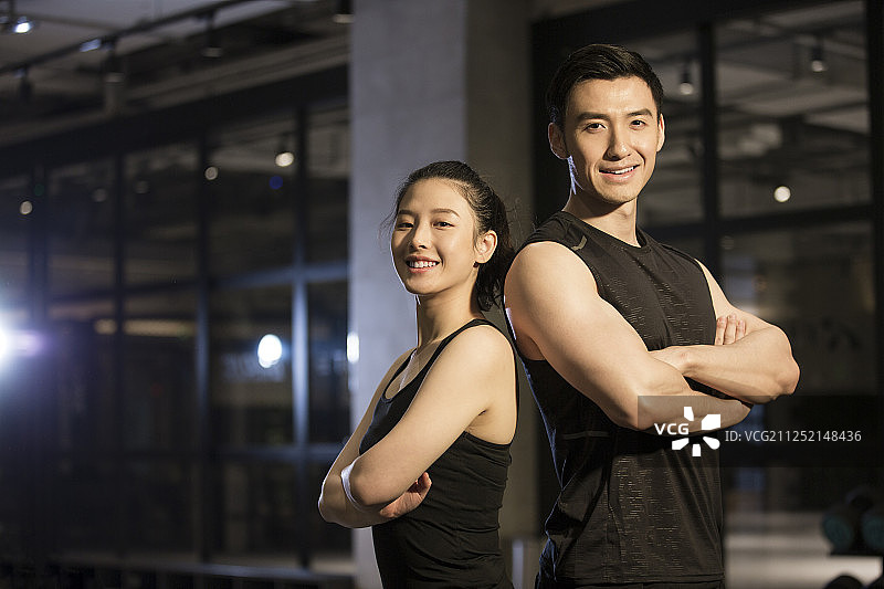 青年男子和青年女子在健身房双臂交叉站着注视镜头图片素材