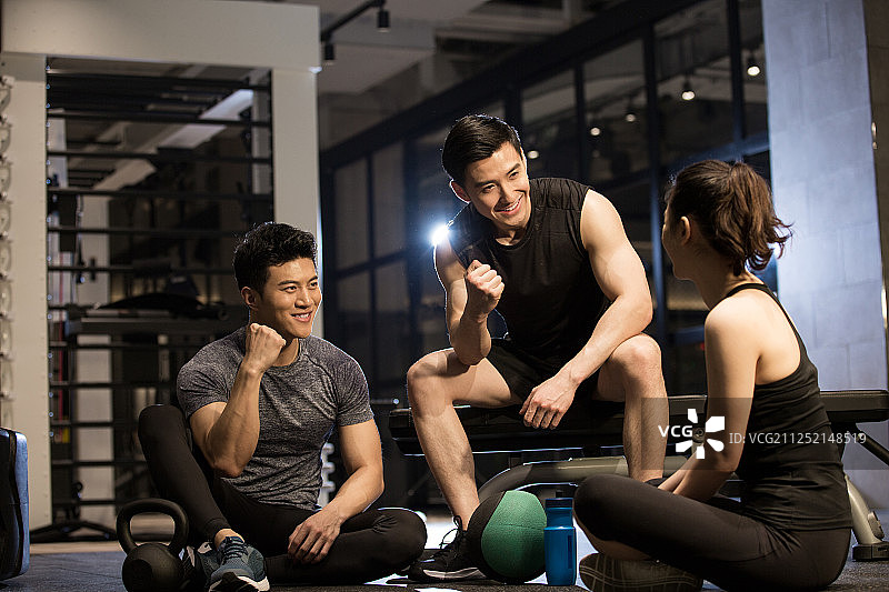 三个青年男女在健身房运动后休息聊天加油图片素材