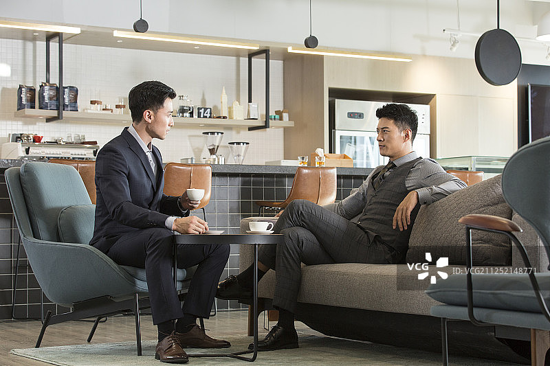 两个男商务青年成功人士在酒店洽谈区商务洽谈图片素材
