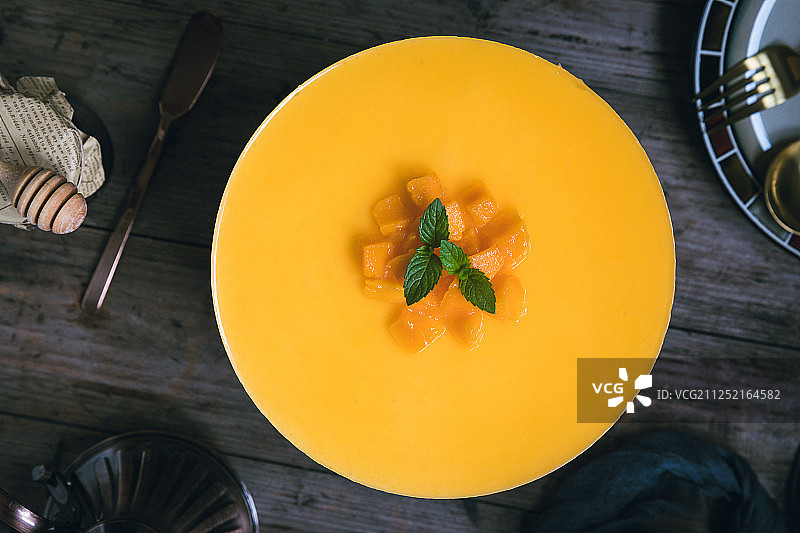 一只新鲜制作的圆形芒果慕斯蛋糕图片素材