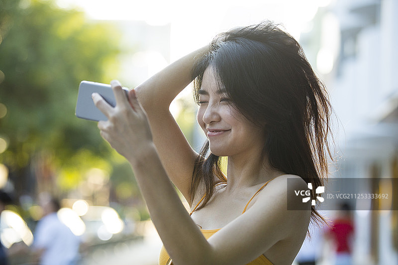 年轻女子在户外旅行度假用手机自拍做网络直播图片素材