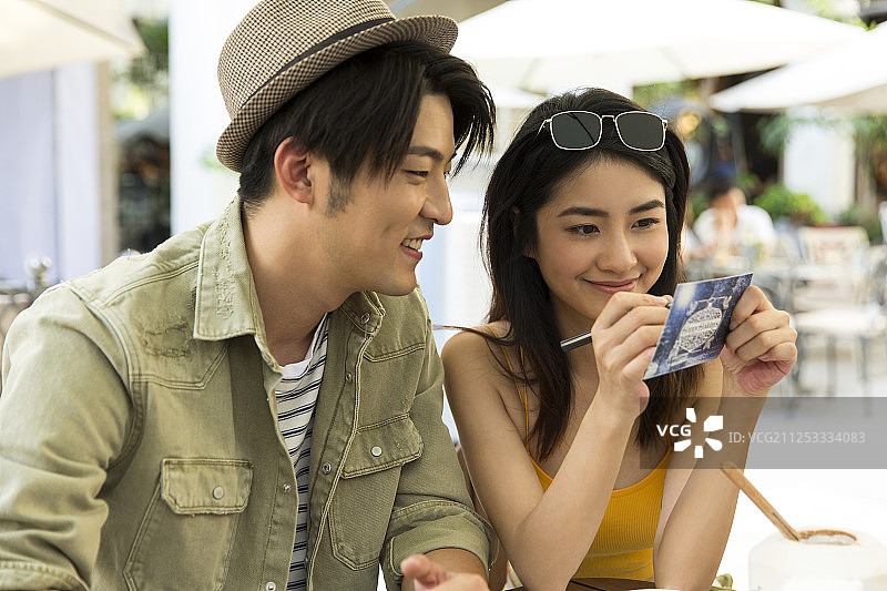 青年男女在露天咖啡馆喝咖啡休息旅游写明信片图片素材