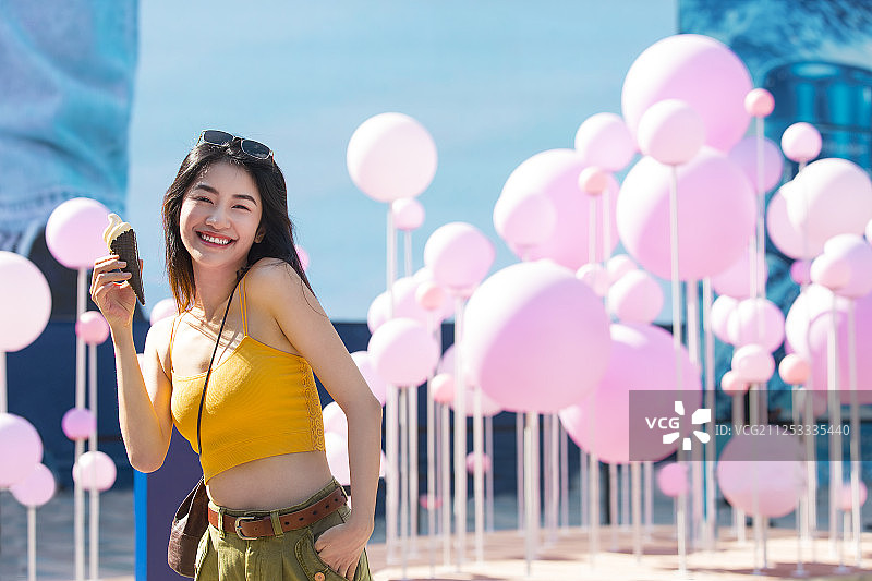 青年女子在户外商业街旅行吃冰淇淋图片素材