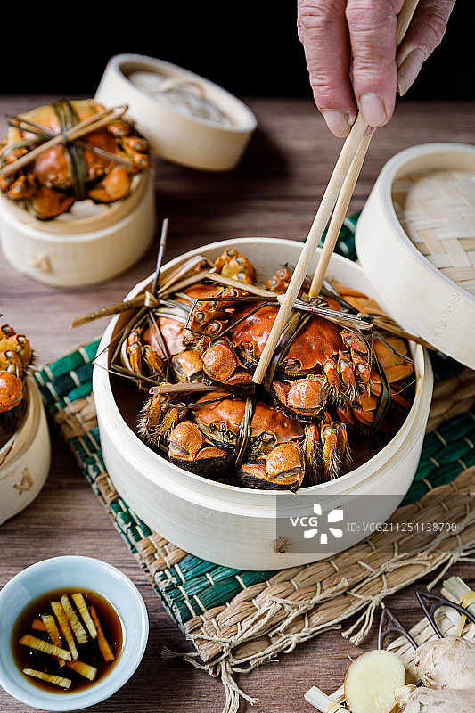 装在蒸笼里的清蒸阳澄湖大闸蟹和调料醋和姜丝图片素材