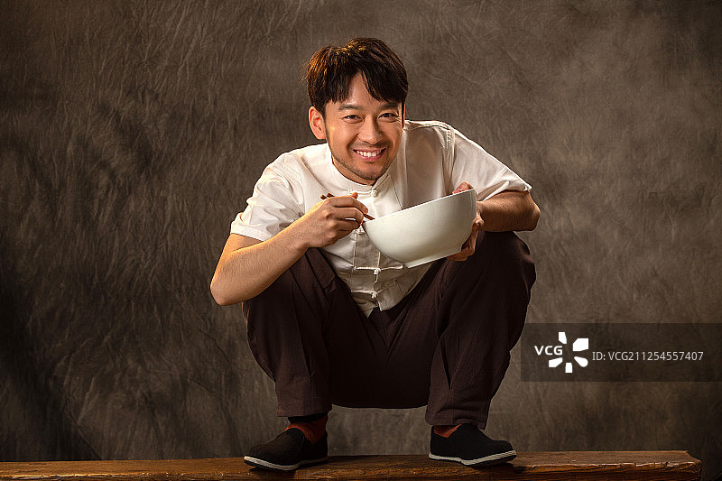 青年男人拿着大碗吃饭图片素材