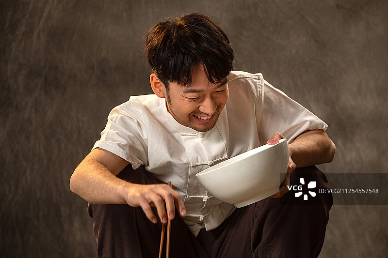 青年男人拿着大碗吃饭图片素材