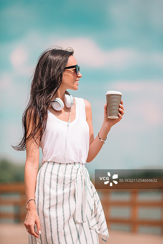 在欧洲城市喝咖啡的快乐年轻都市女性图片素材