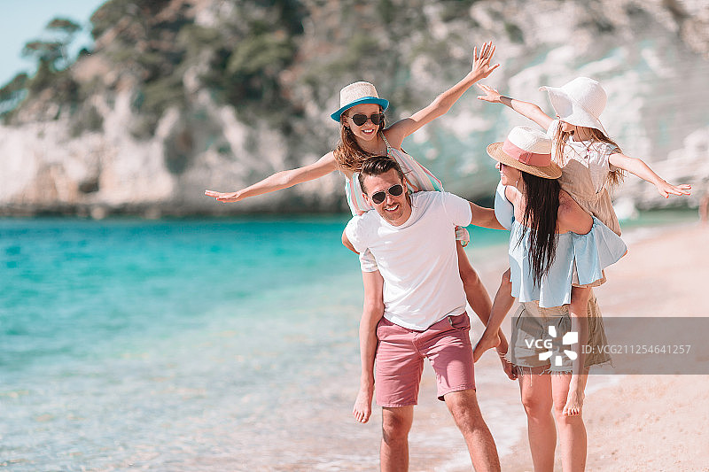 快乐美丽的一家人在海滩上图片素材
