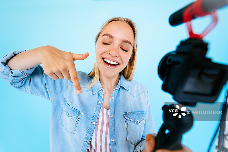 蓝色背景上的美丽女博主图片素材