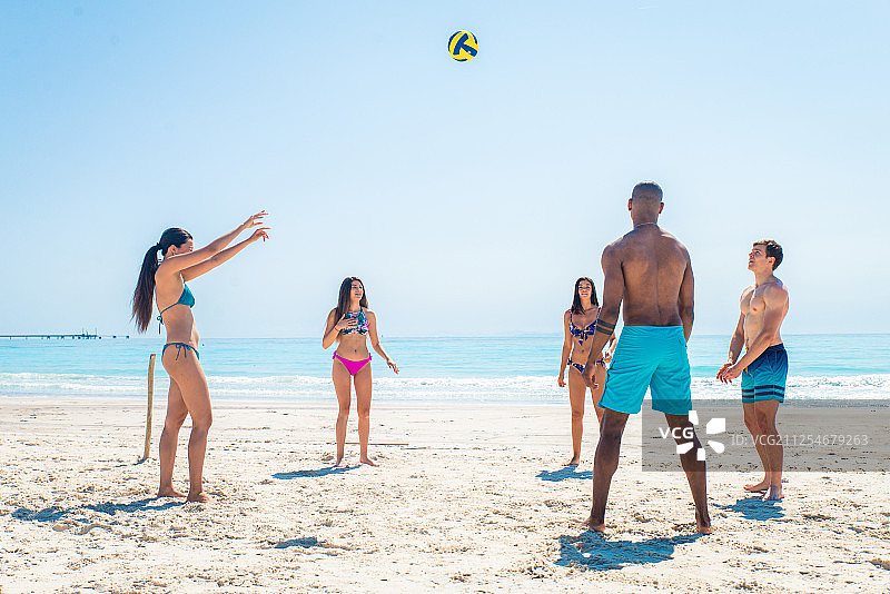 一群年轻的朋友在夏天在沙滩上玩沙滩球图片素材