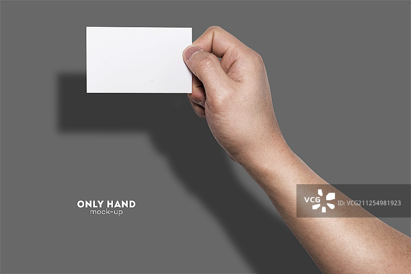 手持空白名片，灰色背景图片素材