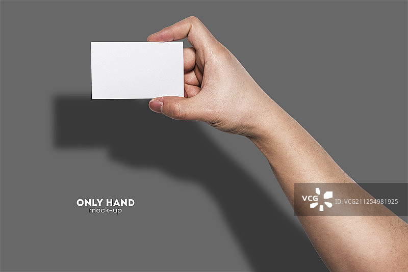 手持空白名片，灰色背景图片素材