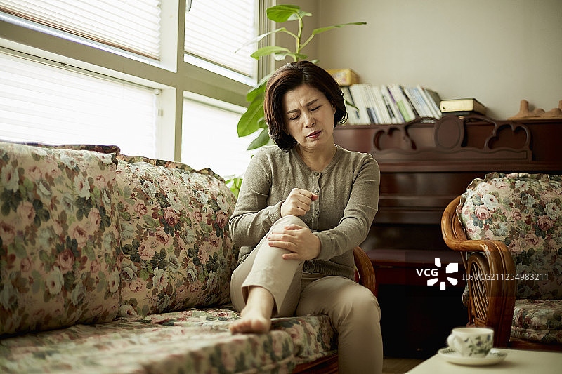 更年期妇女坐在沙发上，身体不适图片素材