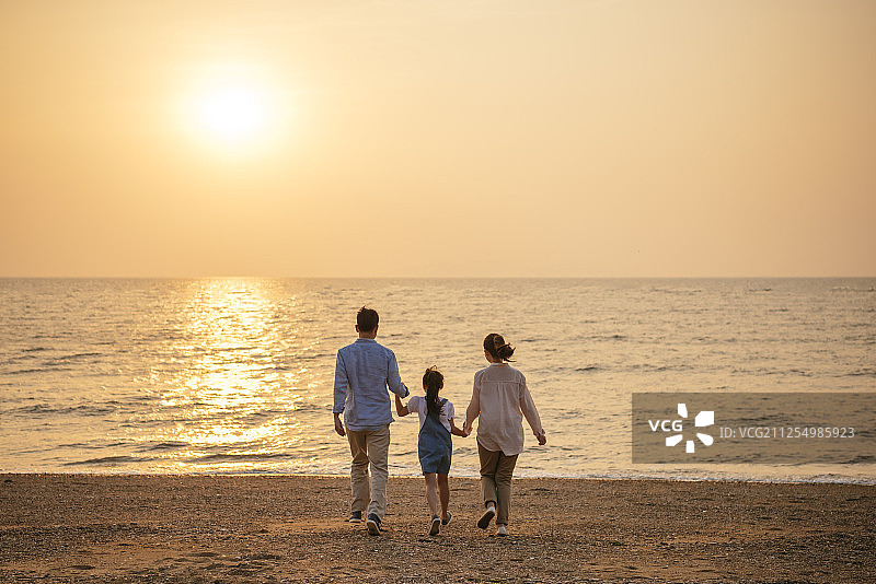 日落时分，一家人在海滩上的照片图片素材