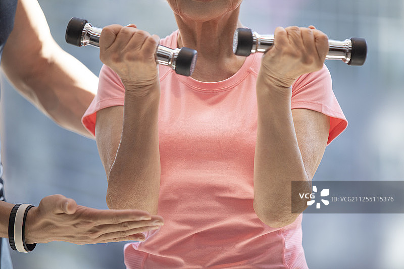 老年女士在健身房举哑铃图片素材