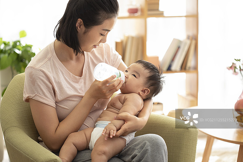 年轻的母亲抱着婴儿喂奶图片素材
