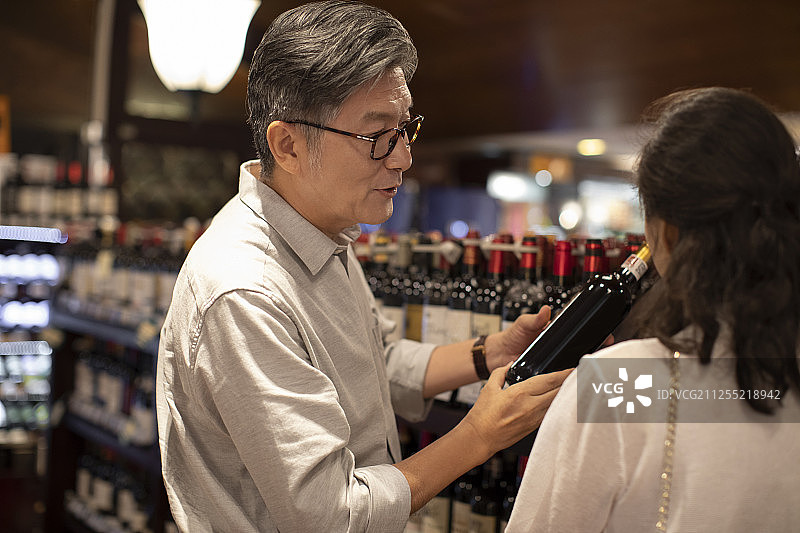 中老年夫妇在超市选购红酒图片素材
