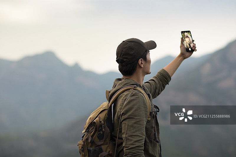 年轻男士在户外使用手机自拍图片素材