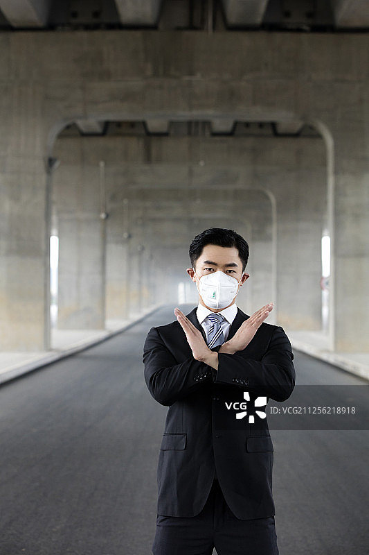 戴口罩的商务男士做手势图片素材