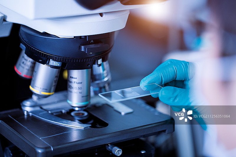 实验人人员使用显微镜观察图片素材