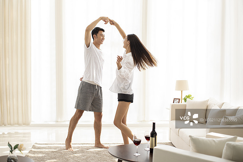 年轻情侣在客厅跳舞图片素材