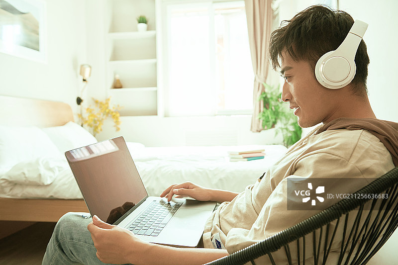单身男青年在单身公寓里使用电脑图片素材
