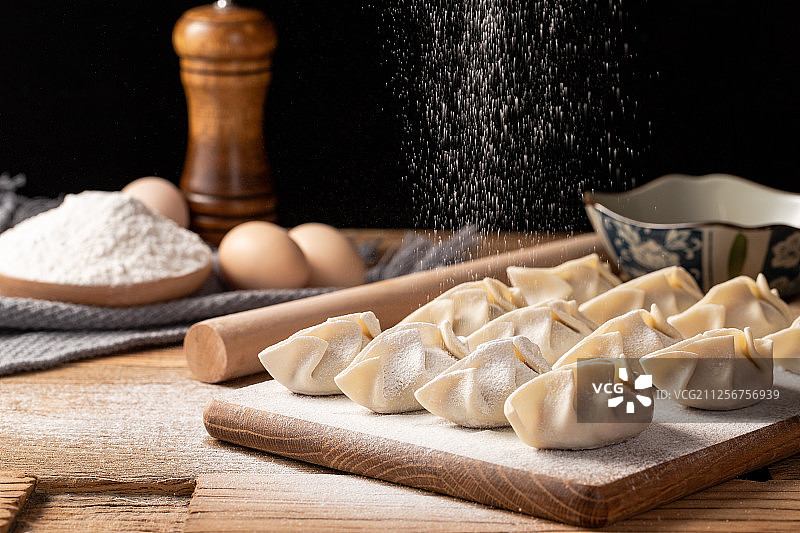 洒满面粉的木板上放着很多手工水饺图片素材