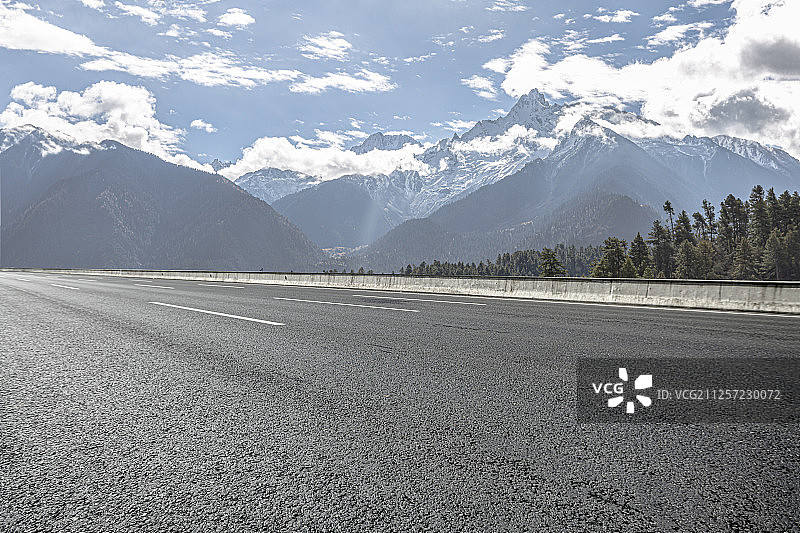 一条柏油路面的快速通道穿过雪山脚下图片素材