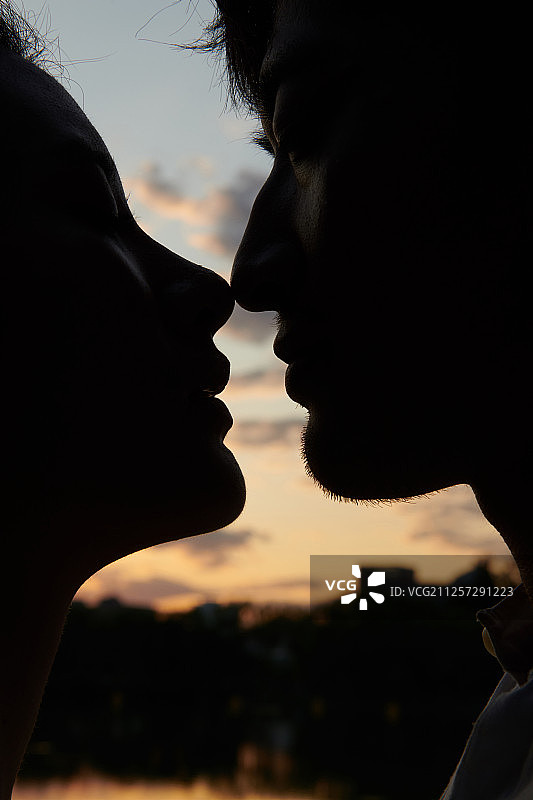 青年情侣在夕阳下亲密图片素材