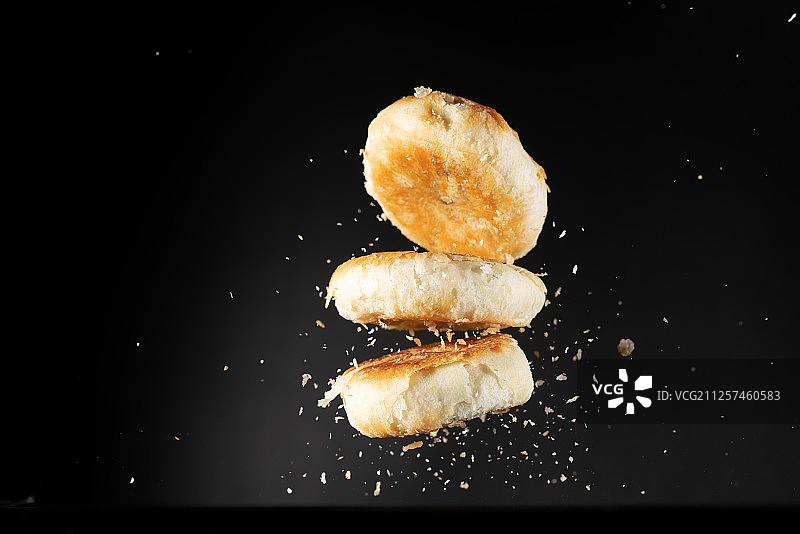老婆饼苏式月饼黑色背景高速棚拍创意摄影瞬间图片素材