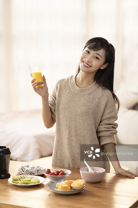 年轻女士在家榨果汁图片素材