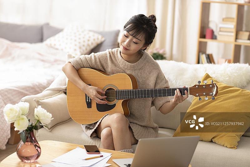 年轻女士在家弹吉他图片素材