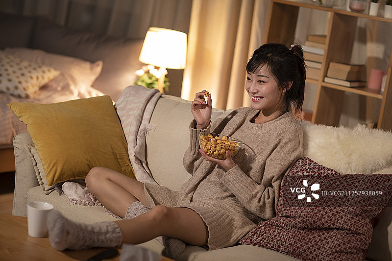 年轻女士在家看电视图片素材