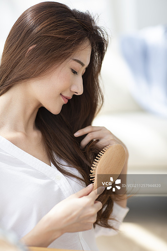 年轻女士在家梳头发图片素材