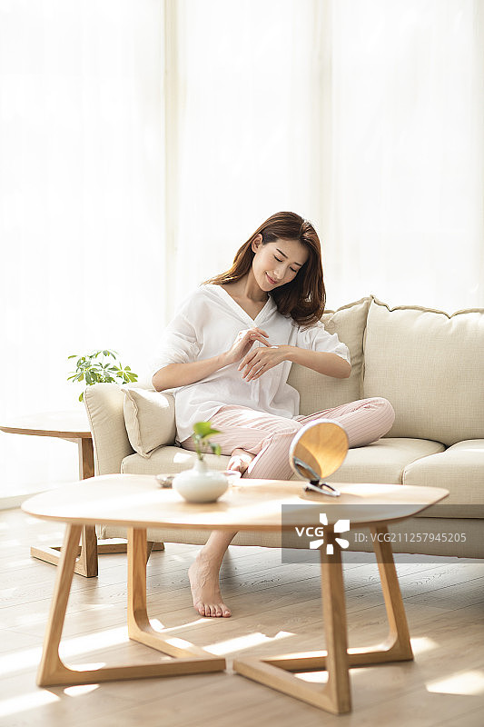 年轻女士在家擦润肤霜图片素材