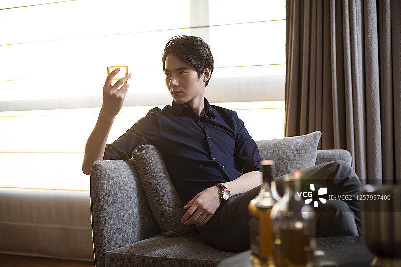 年轻商务男士在酒店房间喝酒图片素材