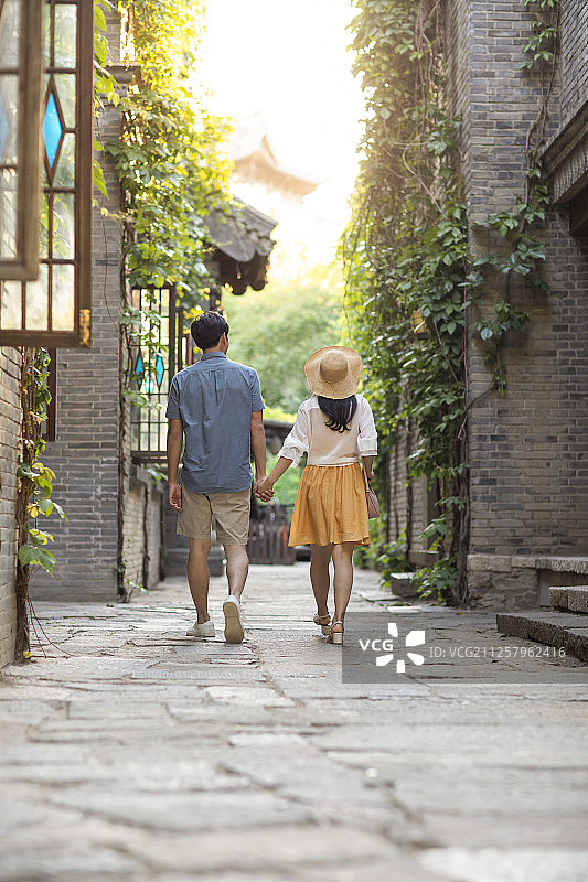 年轻情侣在巷子里走路图片素材