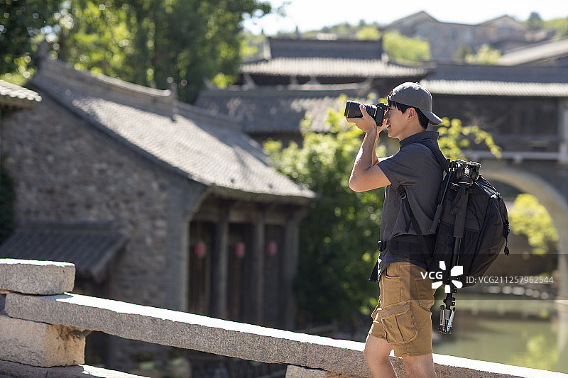 年轻摄影师使用相机摄影图片素材