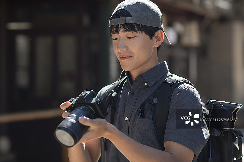 年轻摄影师查看相机里的照片图片素材