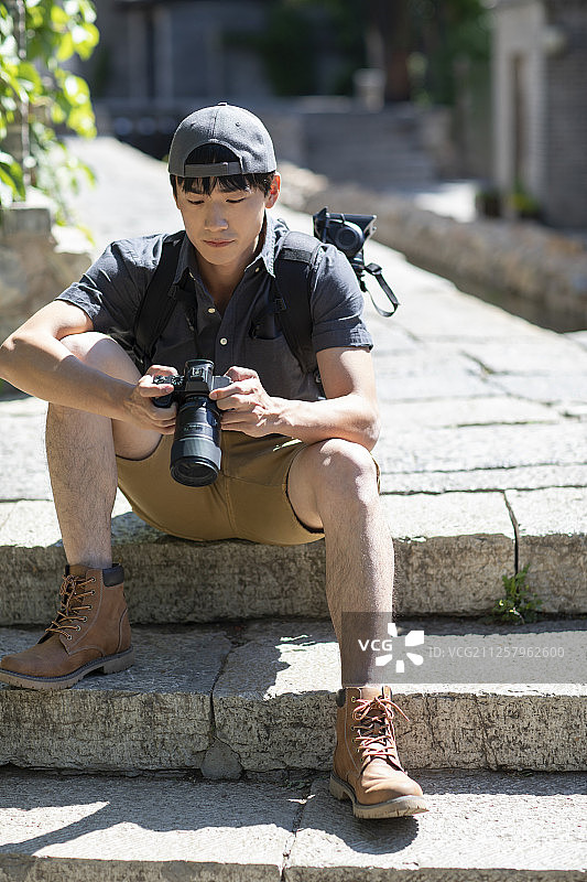 年轻摄影师查看相机里的照片图片素材