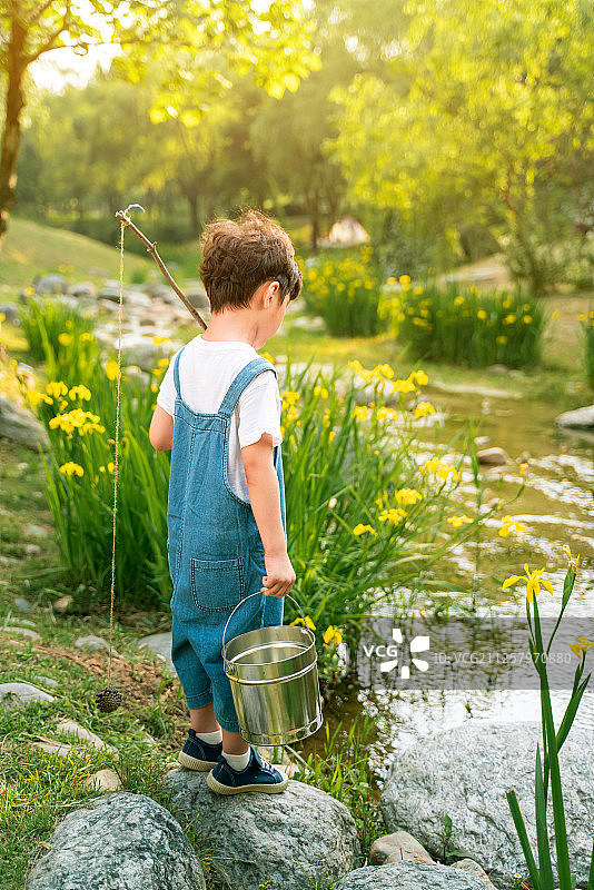 男孩在山谷中划船钓鱼图片素材