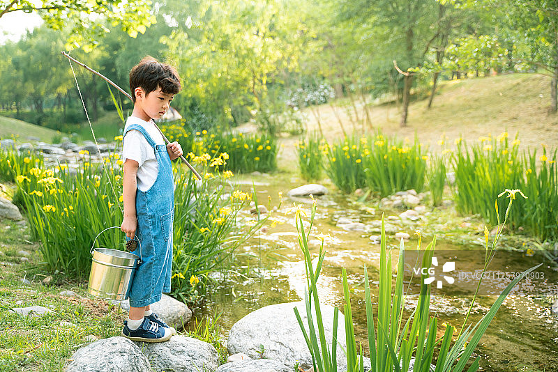 男孩在山谷中划船钓鱼图片素材
