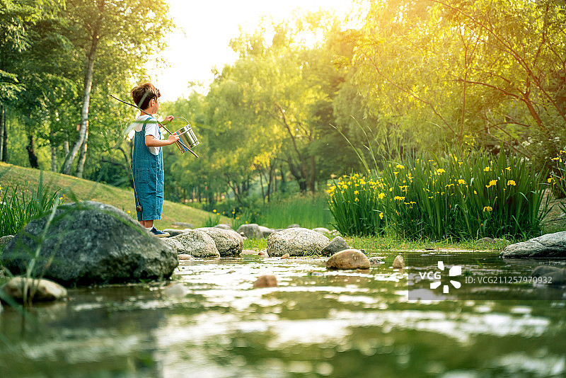 男孩在山谷中划船钓鱼图片素材