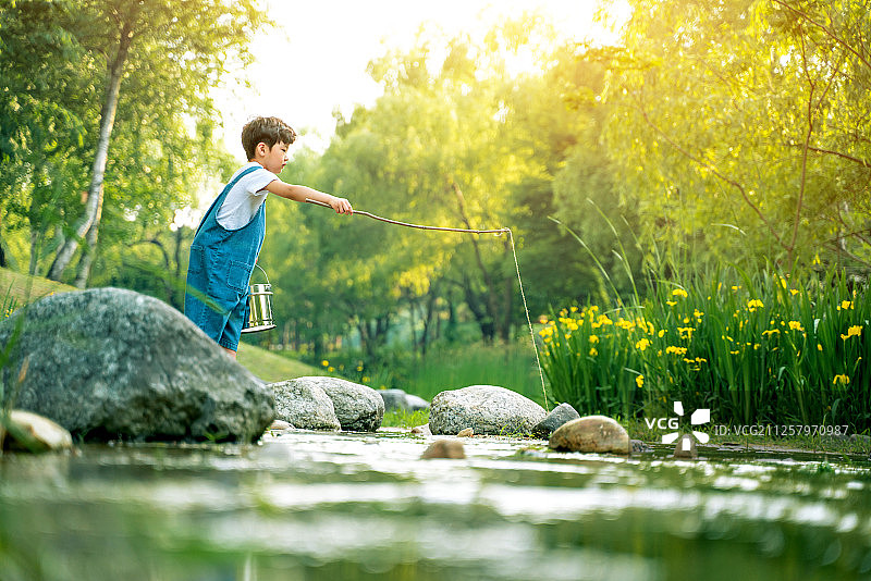 男孩在山谷中划船钓鱼图片素材