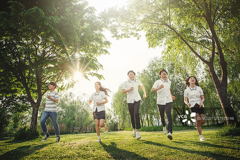 穿着校服笑容灿烂的青少年高中生在森林里放松图片素材